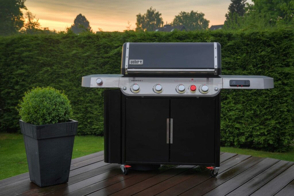 der Weber Genesis-EX-435-Smarter-Gasgrill auf einer Terrasse bei Sonnenuntergang