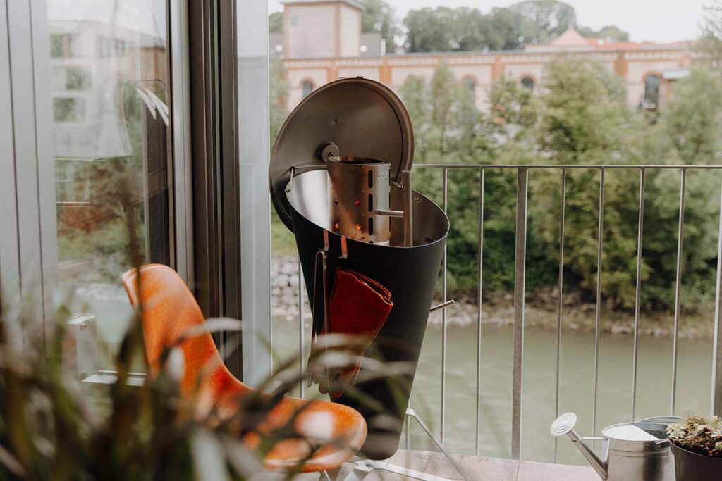 Der Höfats Holzkohlegrill steht auf einem Balkon