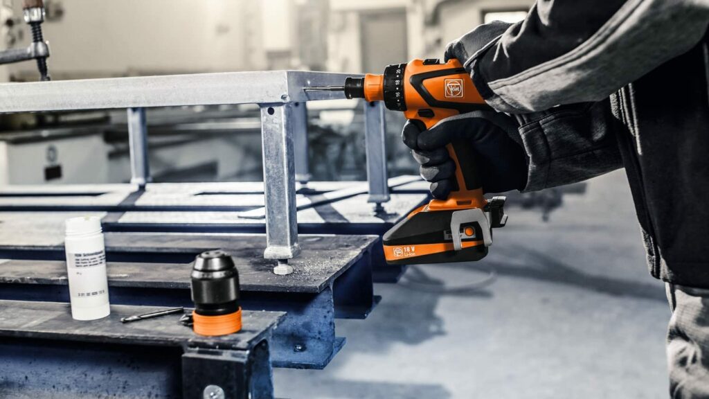 Ein Handwerker bohrt mit der Fein ASCM 18 QM SELECT ist ein 4-Gang Akku-Bohrschrauber mit bürstenlosem Motor und QuickIN MAX Schnittstelle in einen Metallrahmen