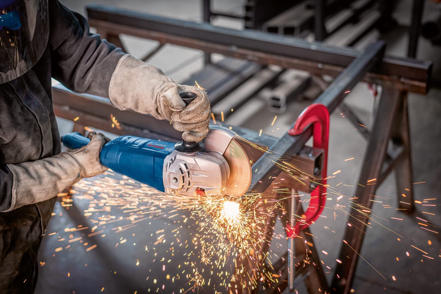 Bosch Professional Winkelschleifer scheift die Kante eines Metallgestells bei dem Funken fliegen