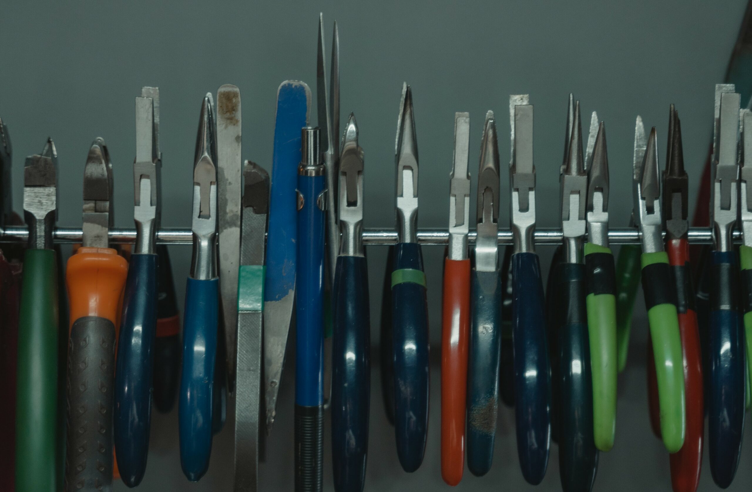 diverse Zangen auf einen Stab aufgereiht und symbolisiert den vergleich von Knipex Zangen und welche man umbedingt im Werkzeugkasten braucht