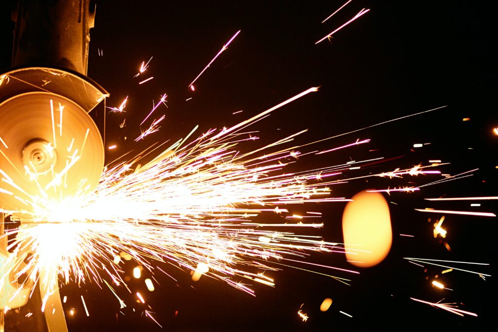 Ein Winkelschleifer von Makita flext durch eine Metallplatte, dabei entstehen vielen Funken