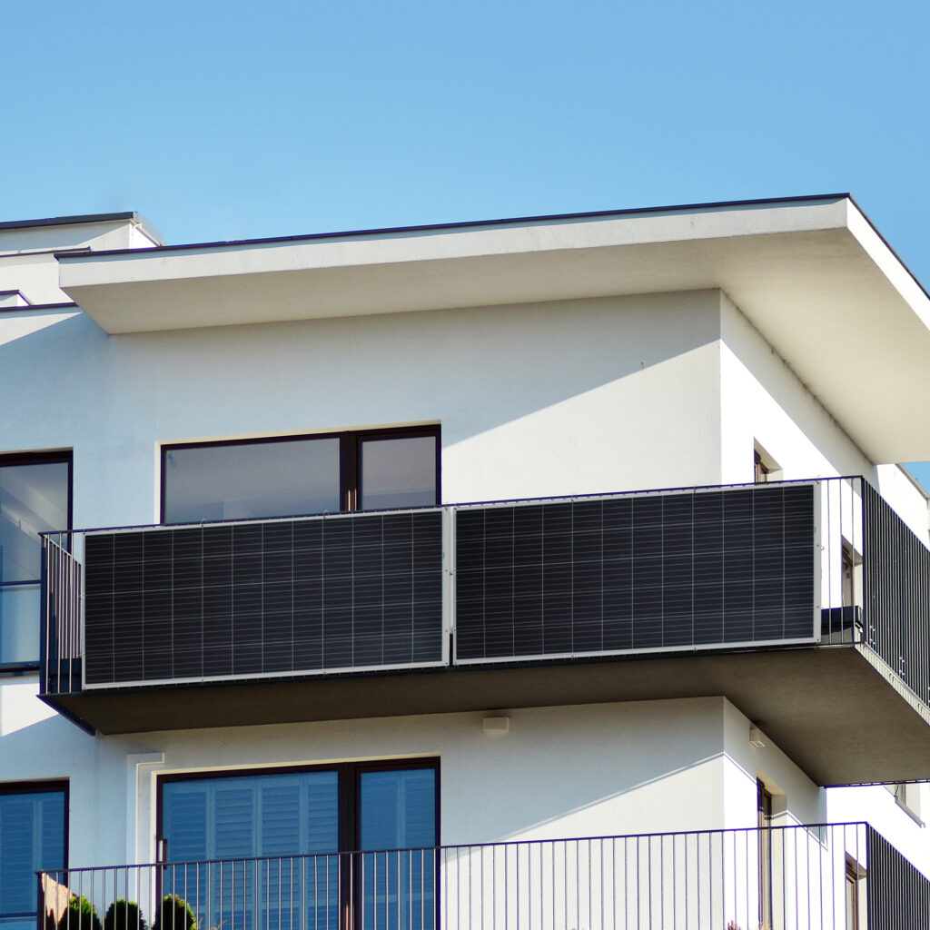 Ein Balkonkraftwerk vertikal an einem Geländer eines Balkon installiert spart Geld und Strom