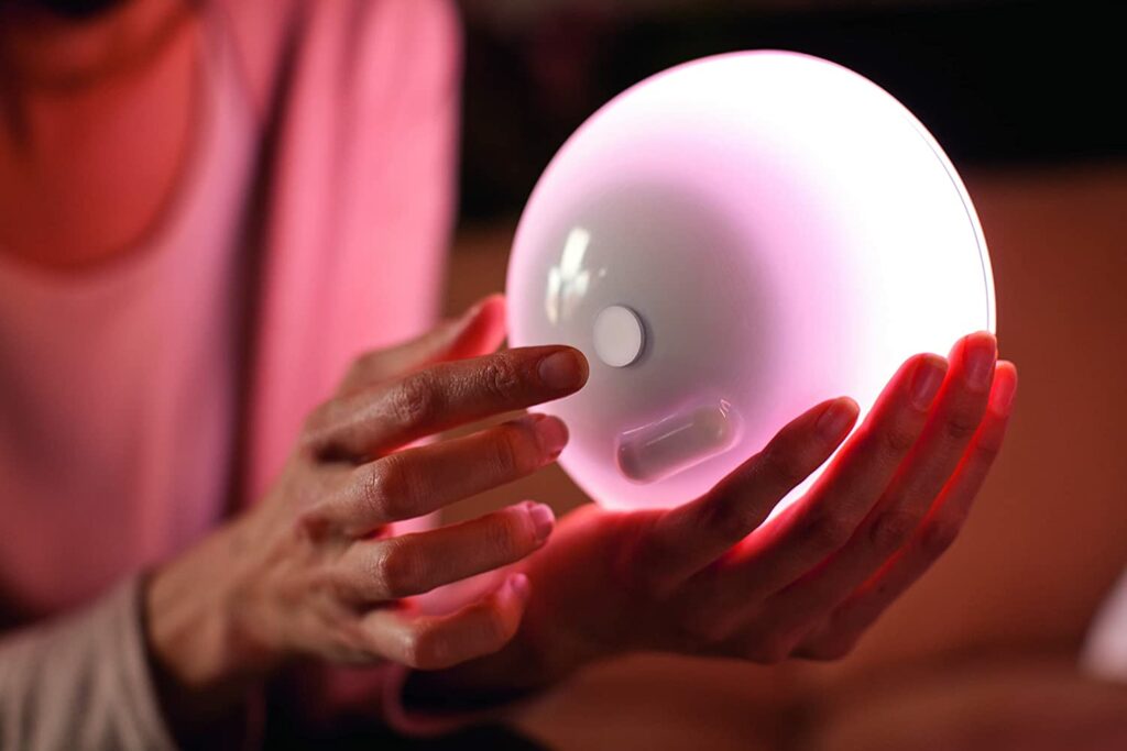 Eine Philips Hue Tischleuchte wird von einer Frau in den Händen gehalten.
