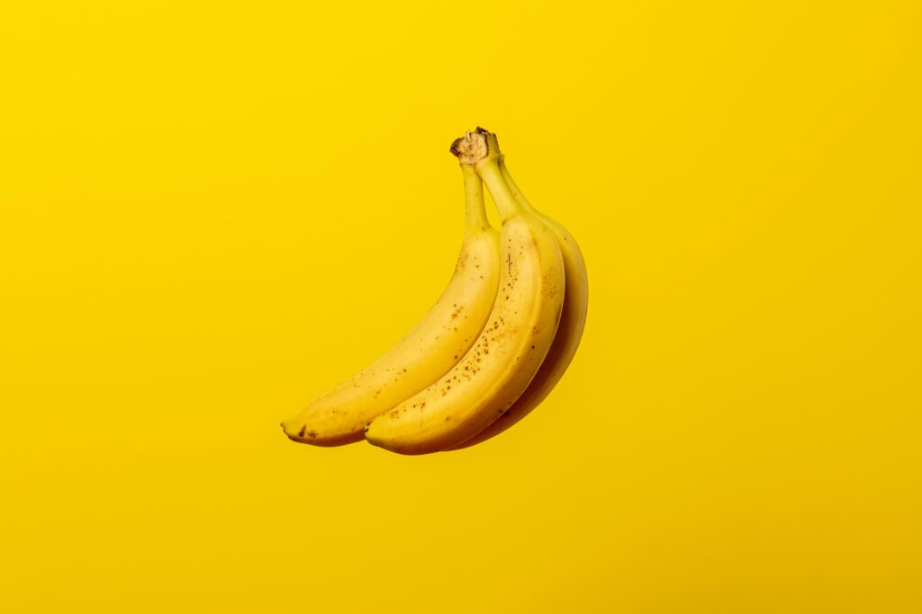Drei Bananen auf gelben untergrund symbolisieren die Möglichkeit aus deren Schale einen Dünger für Pflanzen herzustellen