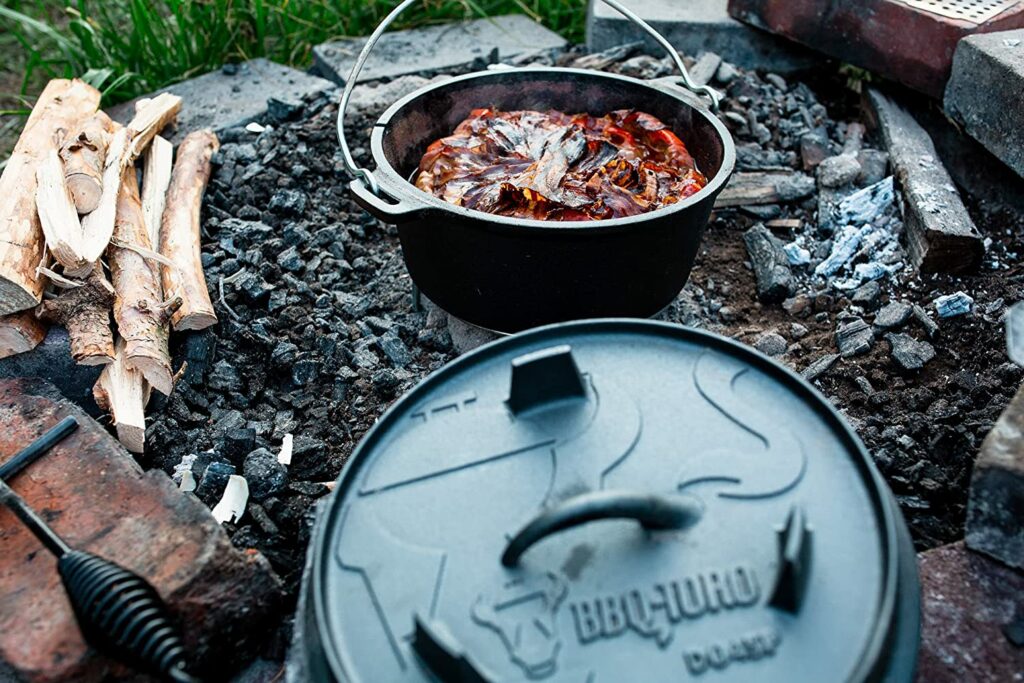 BBQ-Toro Dutch Oven steht in der Glut einer Feuerstelle mit geöffnetem Deckel