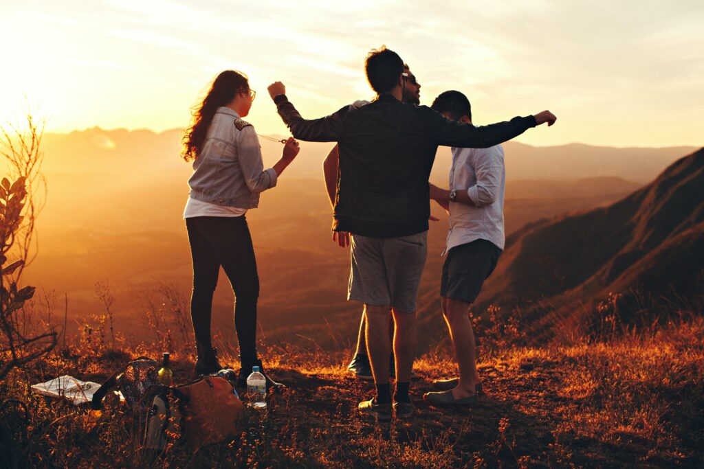 Junge Menschen feiern bei Sonnenuntergang im Freien