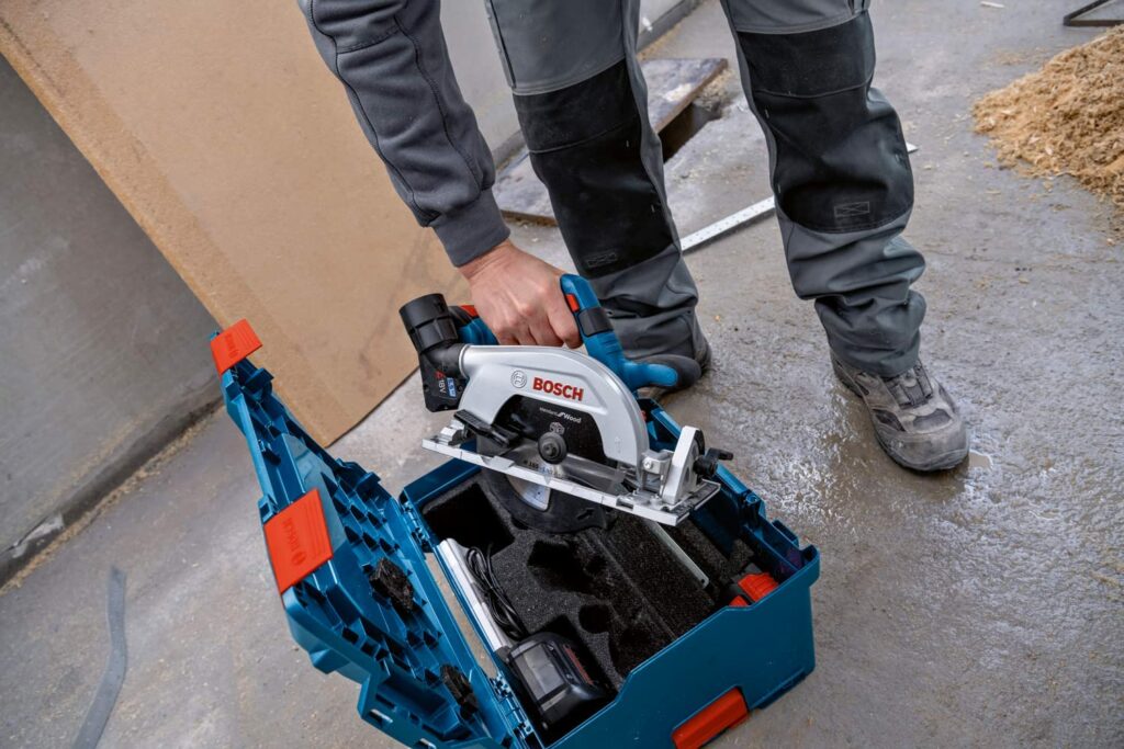 Bosch Professional Akku Kreissäge wird von einem Handwerker aus dem Werkzeugkoffer gehoben