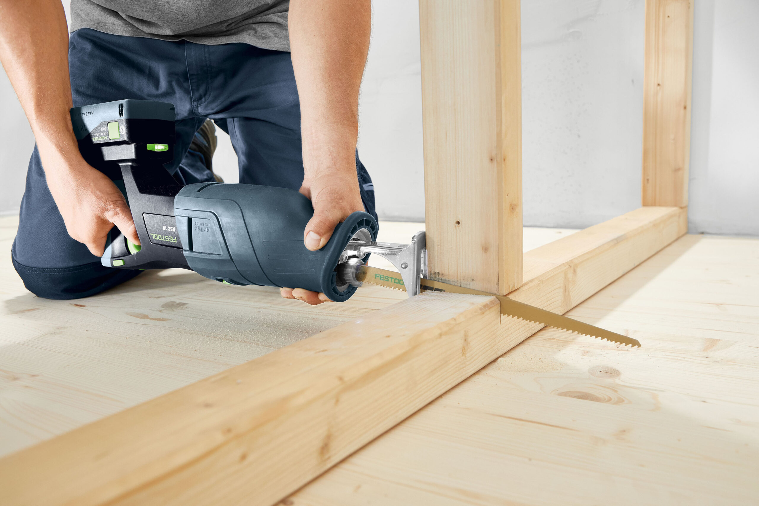 Ein Handwerker sägt mit der neuen Akku-Säbelsäge RSC 18 von Festool durch einen Holzbalken