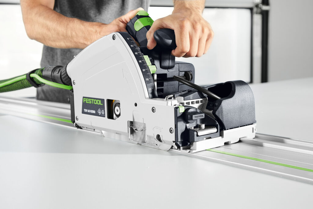 Die neue Vorritzer-Tauchsäge TSV 60 K von Festool wird von einem Handwerker über die Festool Führungsschiene geeführt
