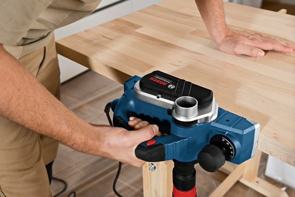 Bosch elektrohobel hobelt die Seite eines Holzbretts
