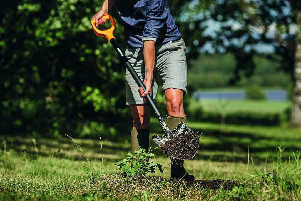 Ein Mann gräbt mit einem Fiskars Spaten ein Loch im Garten